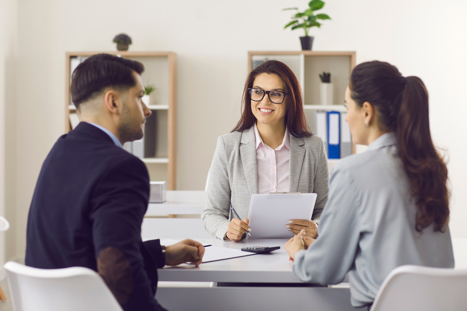 Friendly insurance manager or mortgage broker meeting with clients at her office